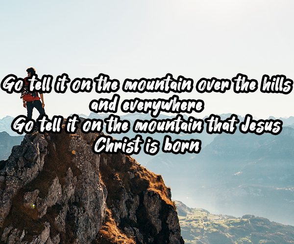 Go Tell It On The Mountain superimposed on a man on a mountaintop