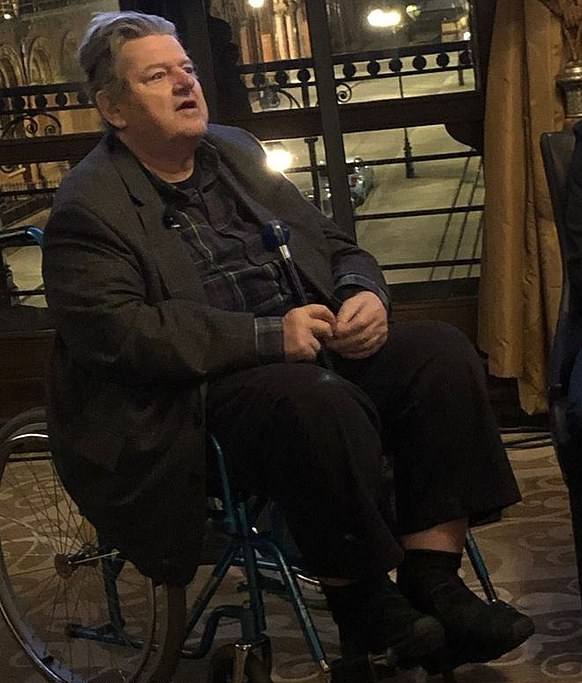 Robbie Coltrane in a wheelchair at a press event for Hagrid's Magical Creatures Motorbike ride, 2019